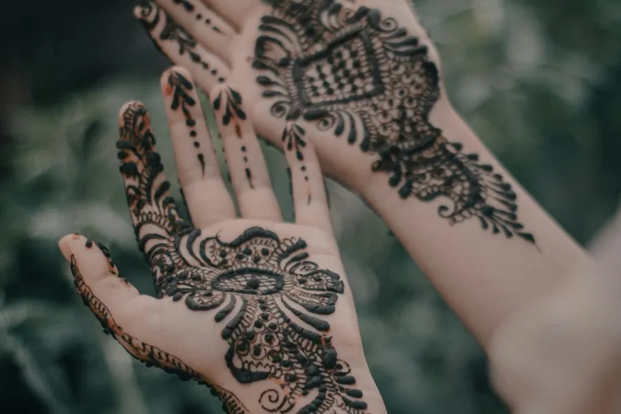 hands with black henna designs